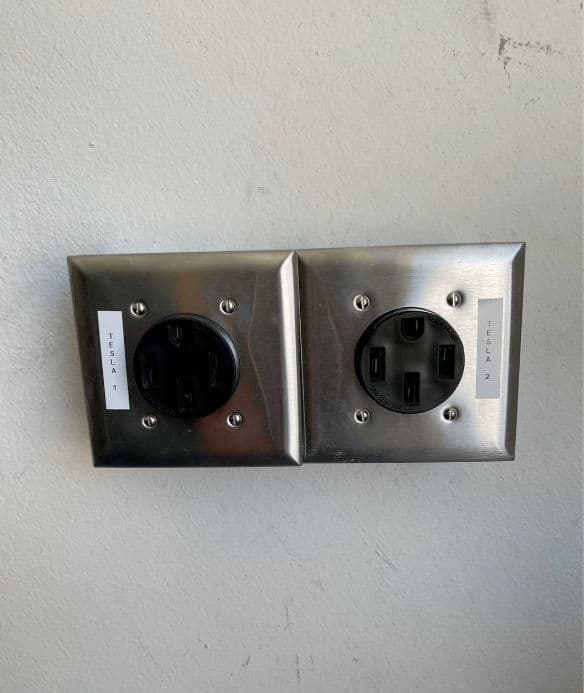 Tesla charging station wall outlets with stainless steel casing.